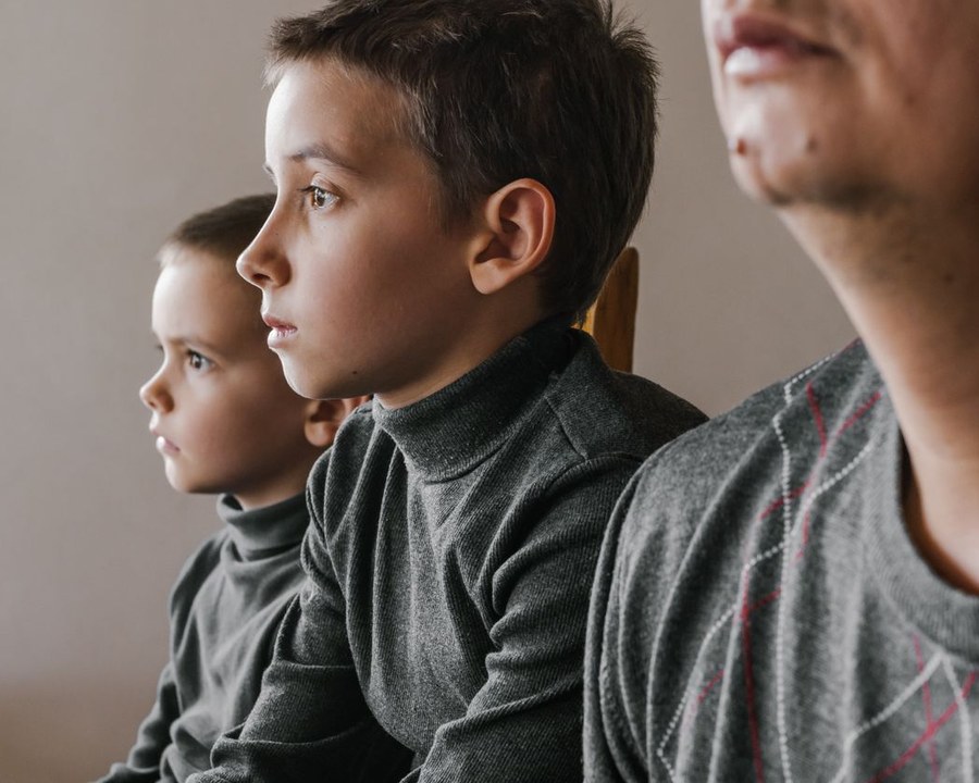 One adult and two children together in a studio profile portrait